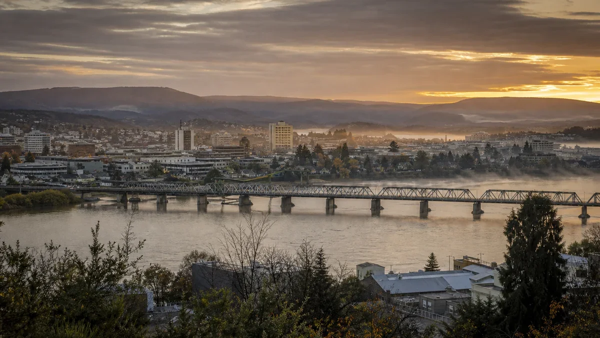 Vista de una ciudad del sur de Chile junto a un río caudaloso al atardecer