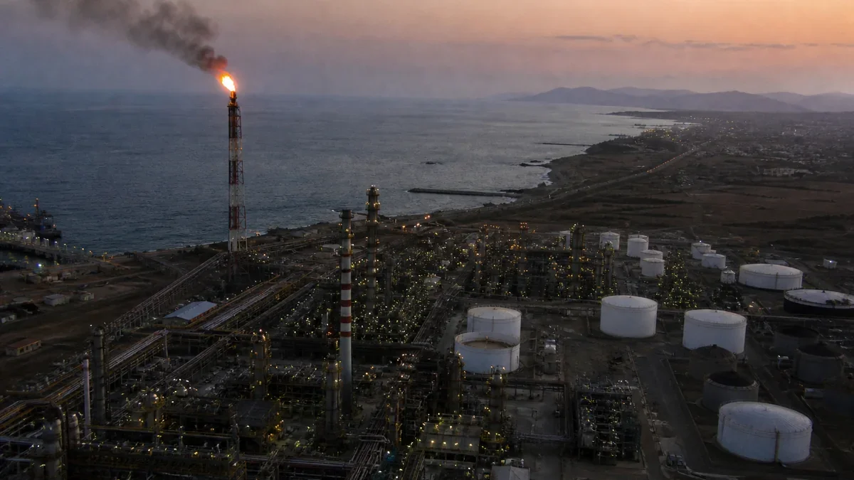 Refinería de petróleo en la costa chilena al atardecer con antorcha encendida